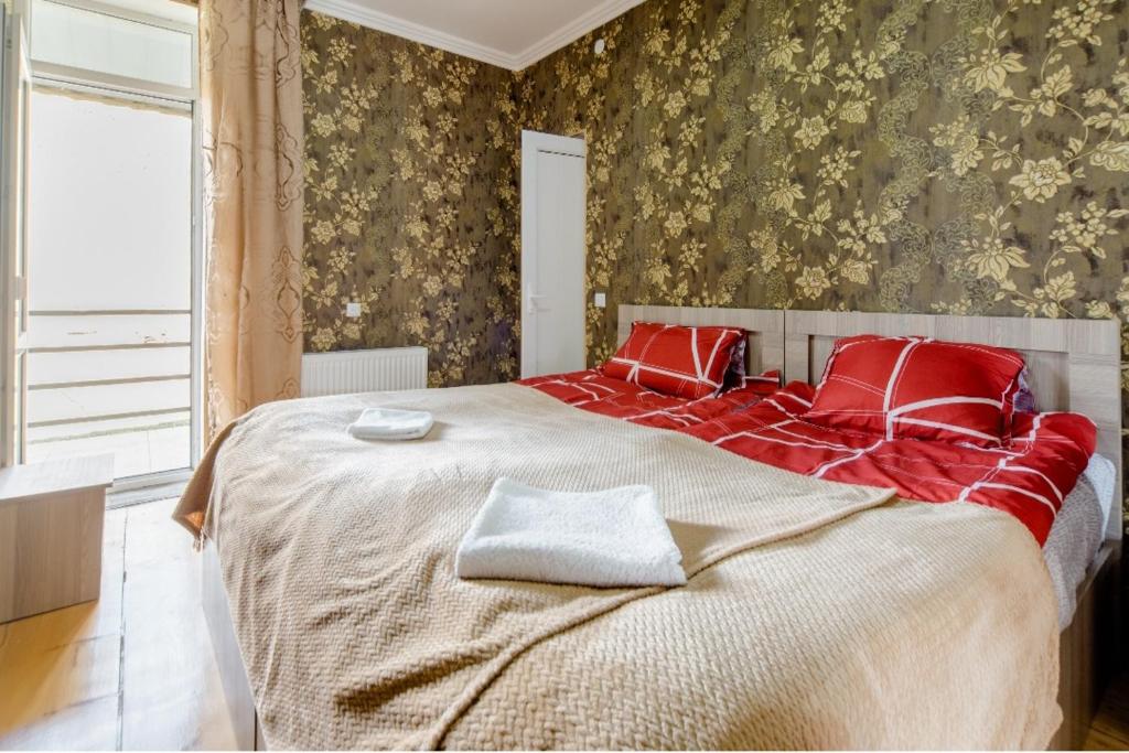卡兹贝吉Hotel Garbani的一间卧室配有一张带红色枕头的大床