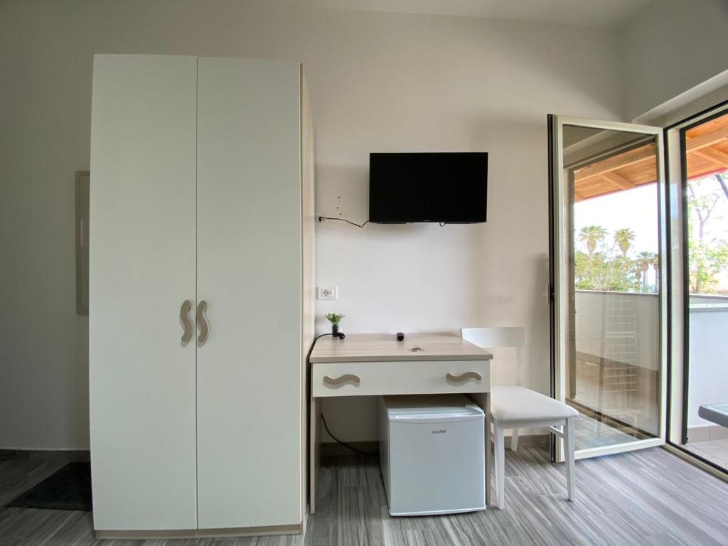 特罗佩阿Accommodetion "Mare Grande"的客房设有书桌和滑动玻璃门