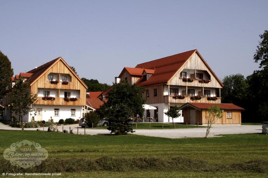 巴特海尔布伦兰德盖斯特豪弗 - 日恩德尔斯米德酒店的一座大型建筑,有两栋房子在田野里