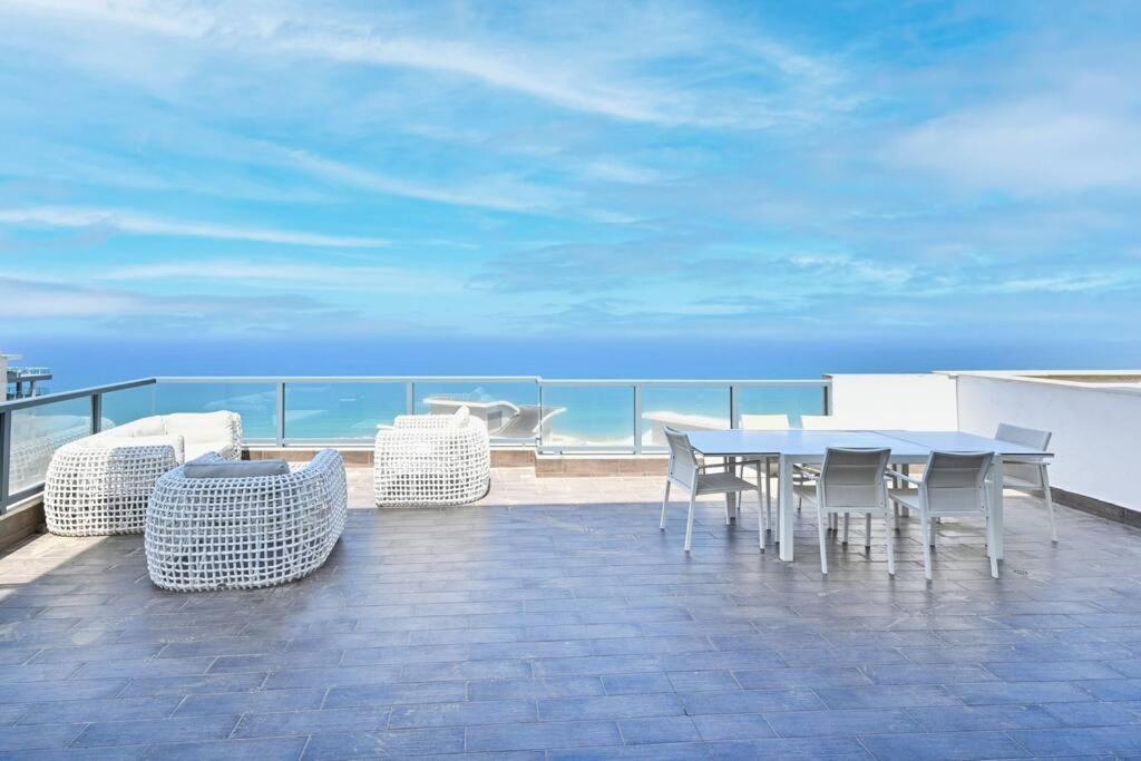 内坦亚Luxury Penthouse in Netanya的阳台配有桌椅