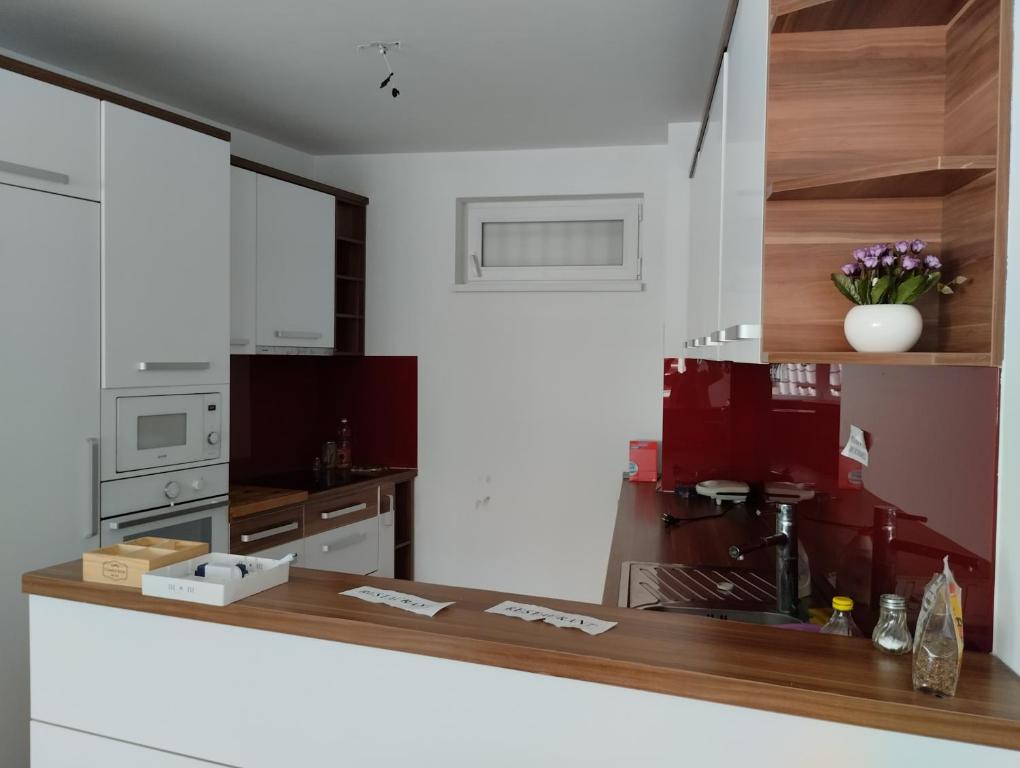 萨拉热窝马哈拉之家的厨房配有白色橱柜和木制台面