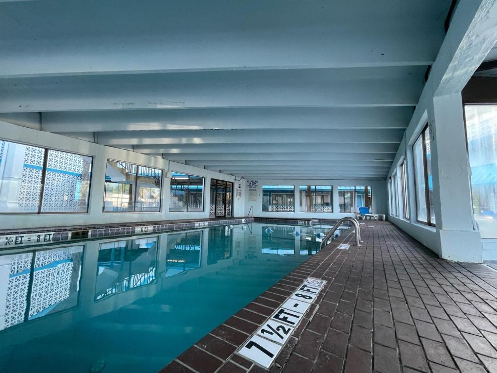 默特尔比奇Polynesian Oceanfront Hotel的建筑物内蓝色水的游泳池