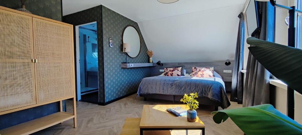 内斯Pension Bakema Ameland的一间卧室配有一张床和镜子