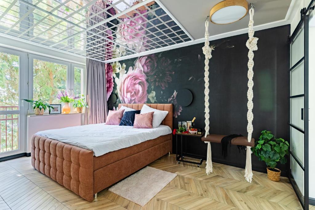 华沙Secret Garden Apartment的卧室配有秋千床和壁画