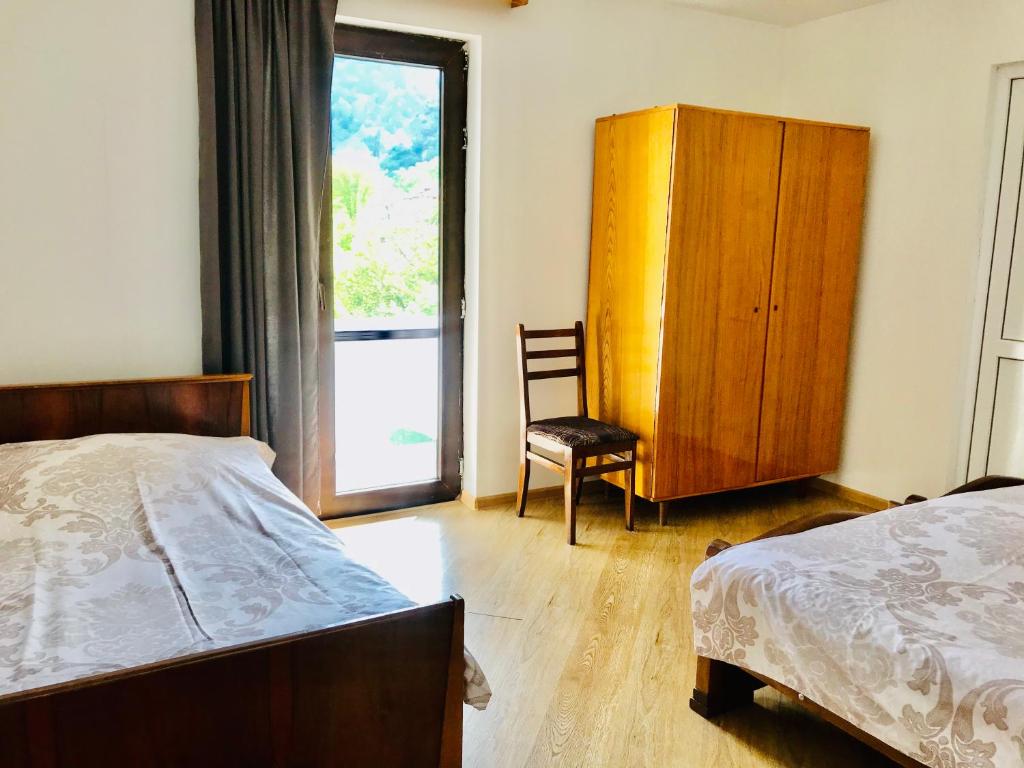 博尔若米Zviad Guest House的卧室配有床、椅子和窗户。
