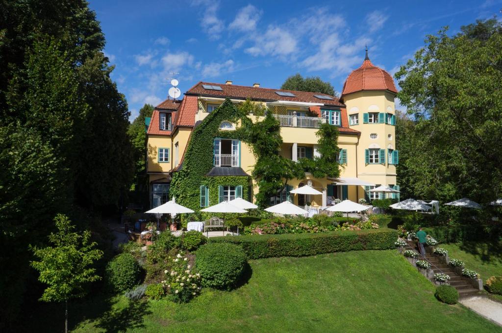 沃尔特湖畔韦尔登Hotel Seeschlößl Velden的享有花园建筑的空中景致