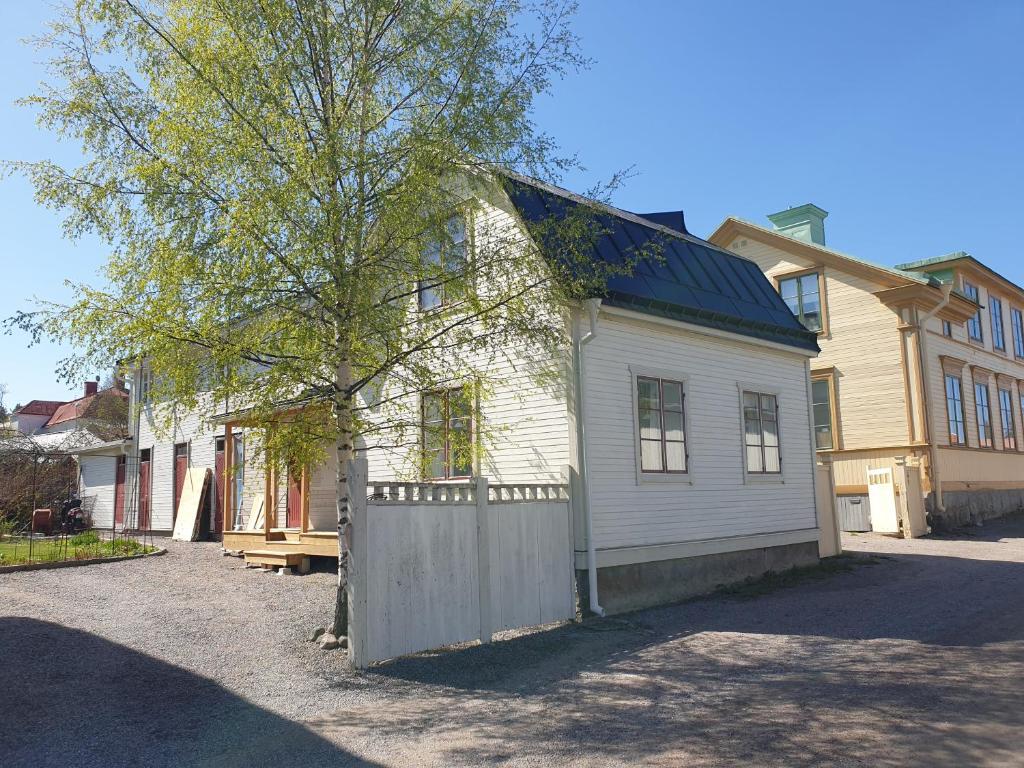 瑟德港Välrenoverad fin lägenhet i charmigt område的白色的房子,有栅栏和树