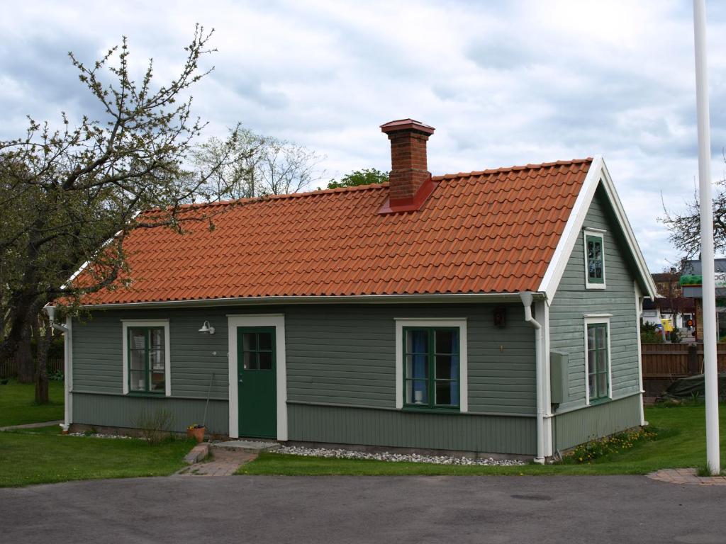 Skänninge斯卡宁住宿加早餐旅馆的一座带橙色屋顶的灰色小房子