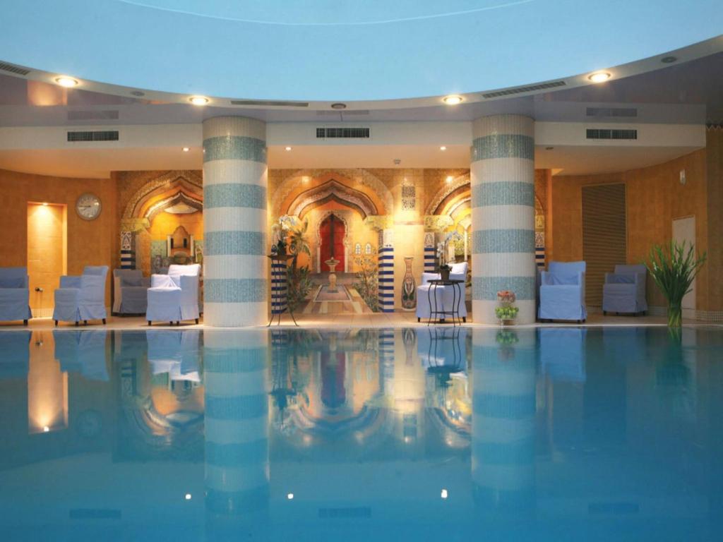 恩波其克Oasis Spa Club Dead Sea Hotel - 18 Plus的一座设有柱子的酒店的大型游泳池