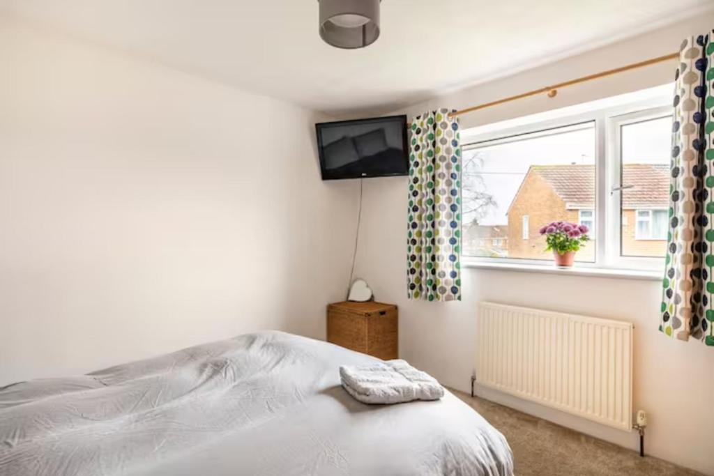 博尔顿Double Room, Large TV, With Great Transport Links的一间卧室设有一张床、一台电视和一个窗口。