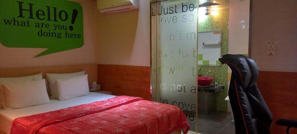 蔚山Design T Motel的卧室配有一张床,墙上有标志