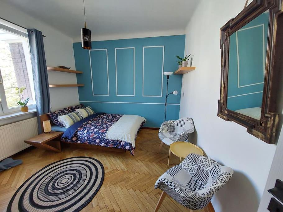 华沙Perfect location, cozy flat的一间卧室配有床、椅子和镜子
