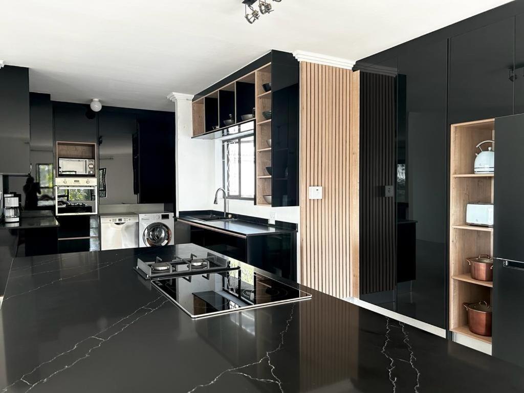 巴利托Luxury on 1B Patricia的厨房配有黑色橱柜和黑色台面