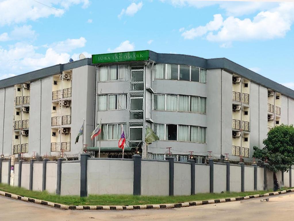 朱巴Juba Landmark Hotel的一座大型公寓楼,上面有绿色标志