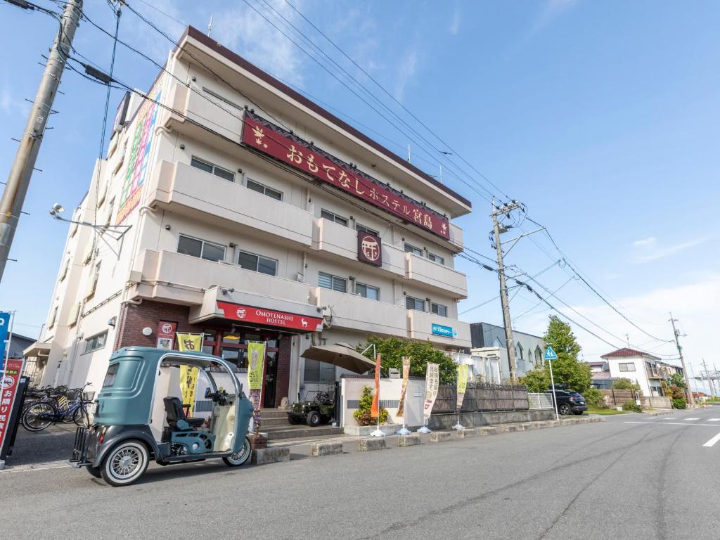 廿日市宫岛奥莫特纳希旅舍的停在大楼前的小汽车