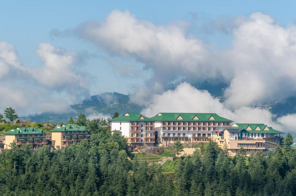 西姆拉Taj Theog Resort & Spa Shimla的树 ⁇ 山顶的酒店