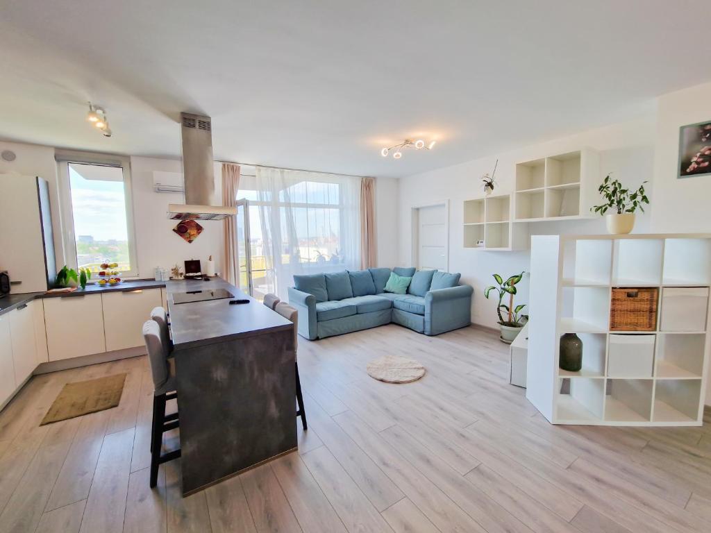 蒂米什瓦拉AZUR Apartment的大型厨房以及带蓝色沙发的起居室。