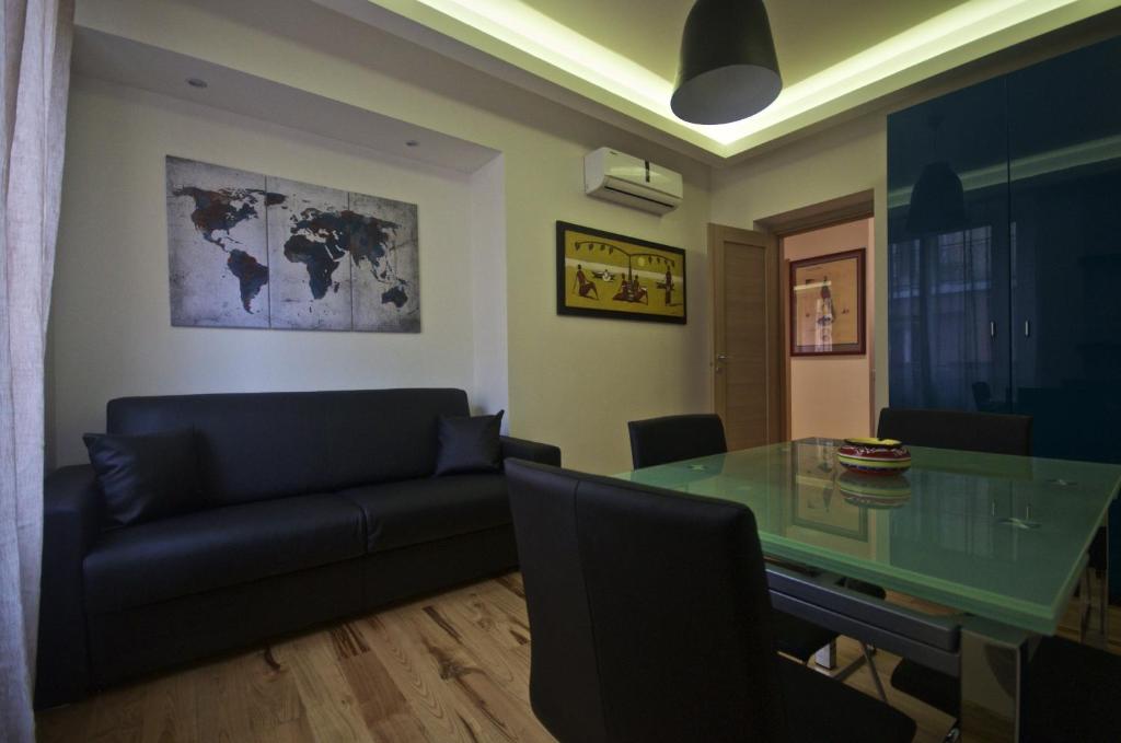 罗马皮拉米蒂公寓的客厅配有玻璃桌和沙发