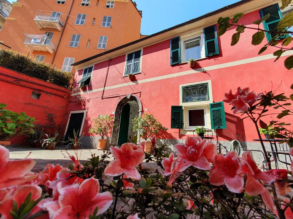 斯培西亚Boutique Hotel Novecento的前面有鲜花的粉红色建筑