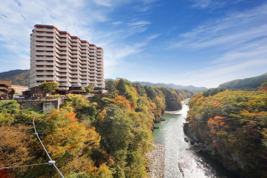 日光鬼怒川日光酒店的河边的山丘上的建筑