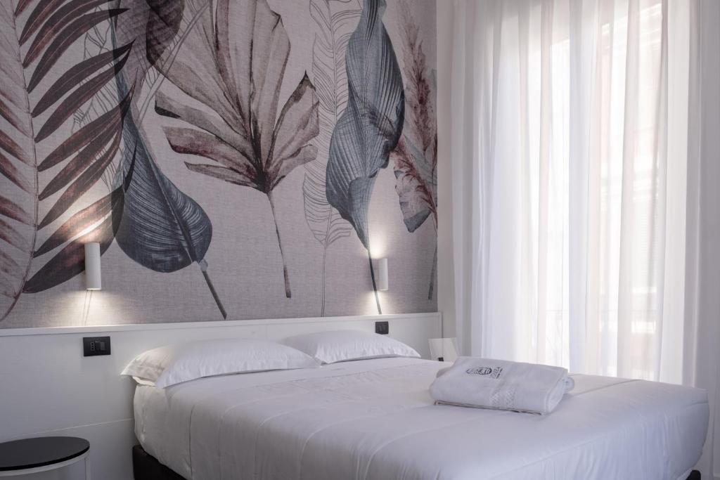 雷焦卡拉布里亚Domea Superior Rooms Bed and Breakfast的卧室配有一张白色床,墙上挂有绘画作品
