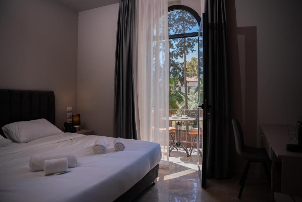 耶路撒冷All Seasons Boutique Hotel - Jerusalem的一间卧室配有一张床、一张书桌和一个窗户。