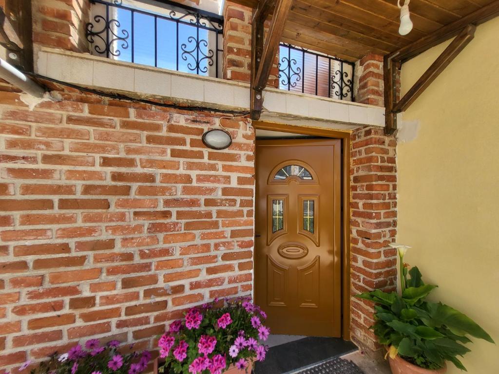 萨兰达Villa Sotiri的砖房,有棕色的门和鲜花
