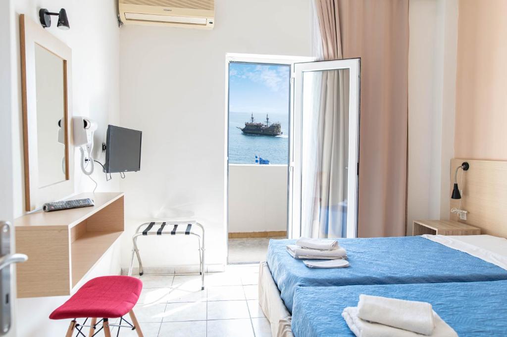 科斯镇阿奇里斯公寓式酒店的一间卧室配有一张床,享有海景