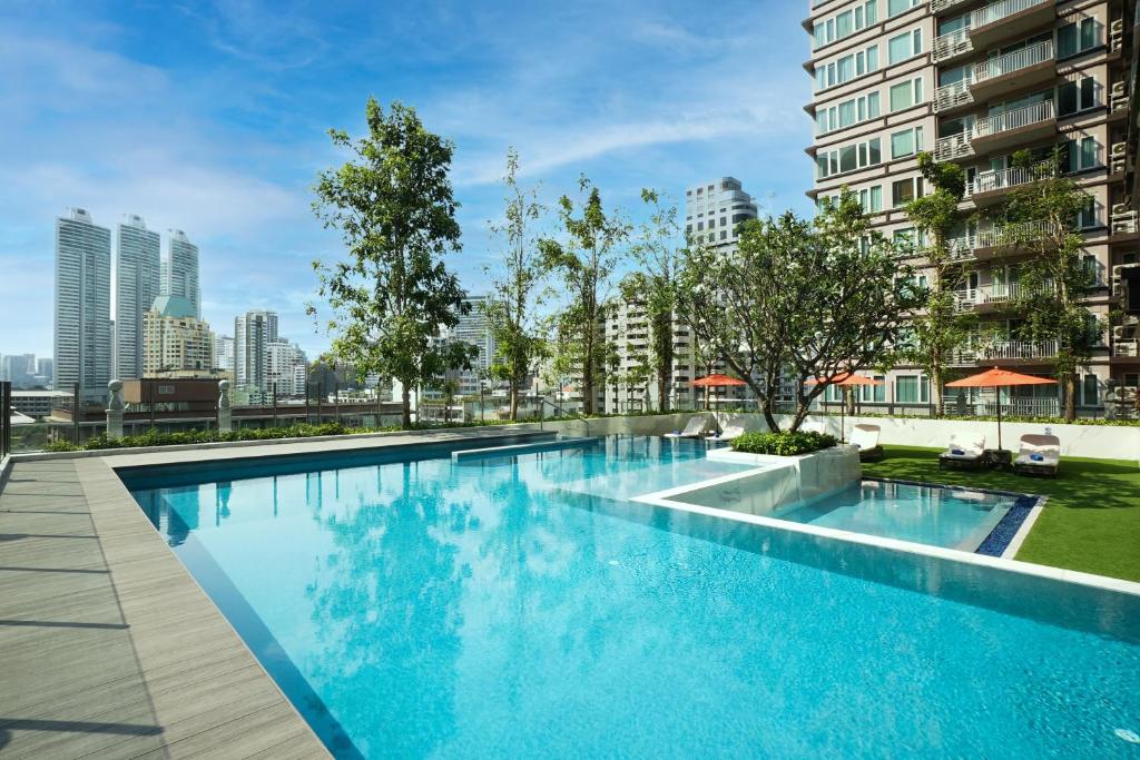 曼谷SILQ Hotel & Residence, Managed by The Ascott Limited的一座位于城市的游泳池,有高大的建筑