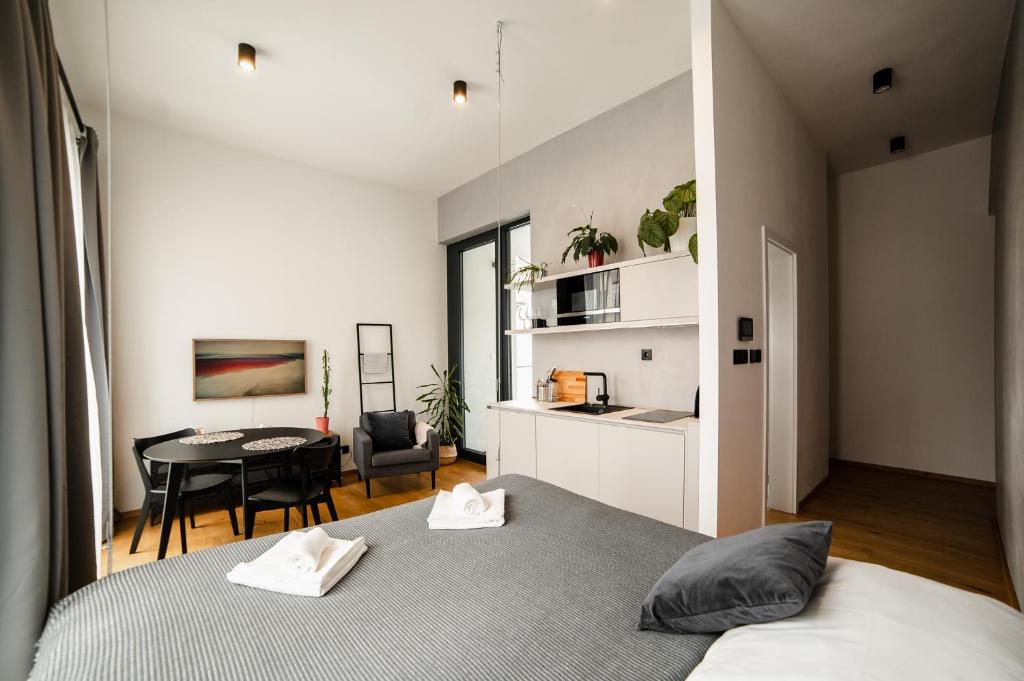 日利纳Piano apartments - LICITY的一间带两张床和一张桌子的卧室以及一间厨房