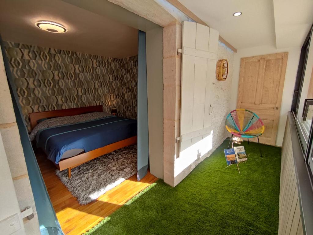 尚帕尼奥勒Logis 39的一间卧室设有一张床,另一间设有绿草。