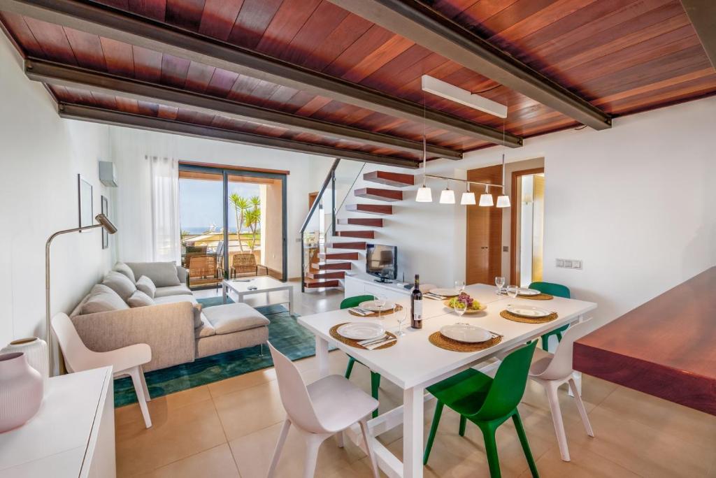 卢斯Mar da Luz Resort的厨房以及带桌椅的起居室。