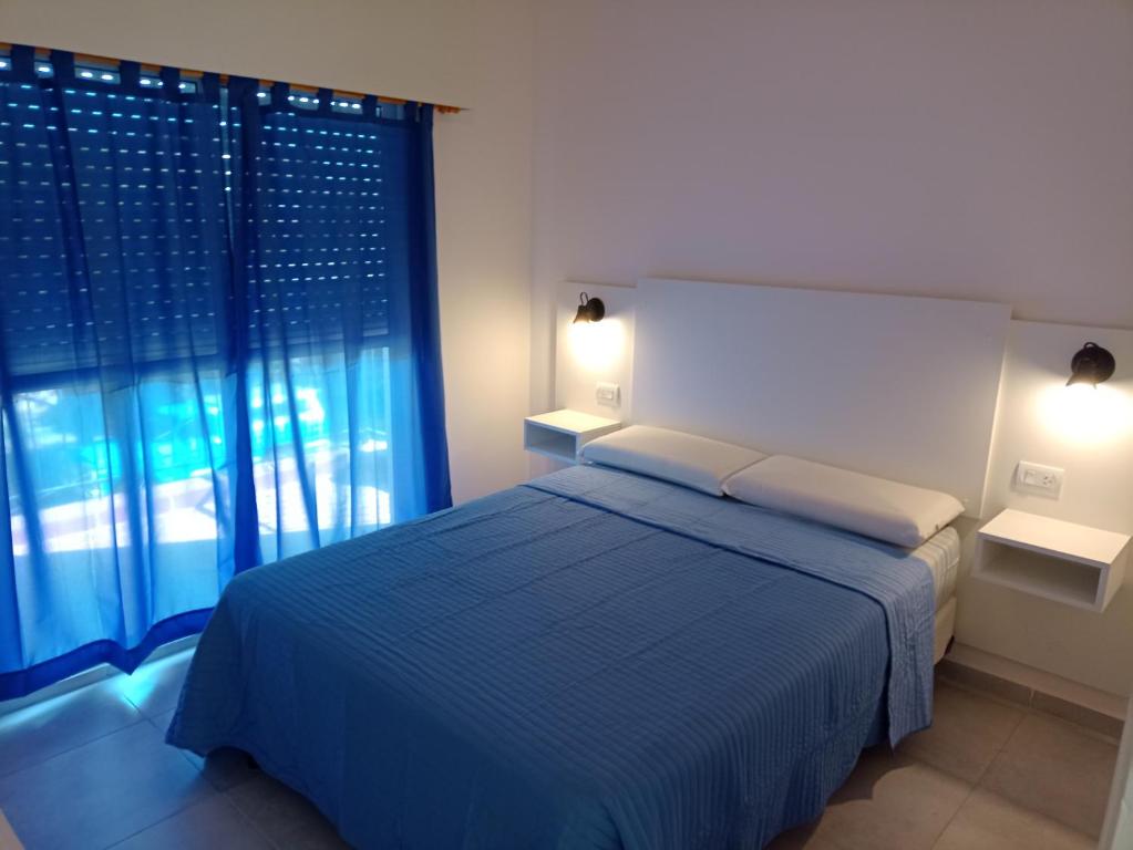 贝纳多图埃托Departamento en primer piso的一间卧室设有蓝色的床和窗户。