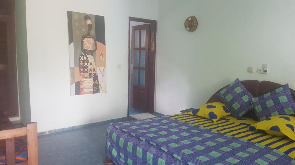 大巴萨姆Capriccio的一间卧室配有一张带蓝色和绿色棉被的床