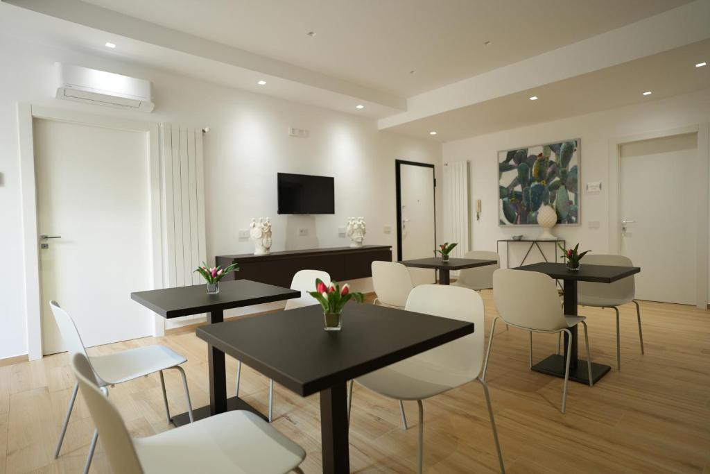 特拉帕尼Enea Suite的客厅配有桌椅和电视