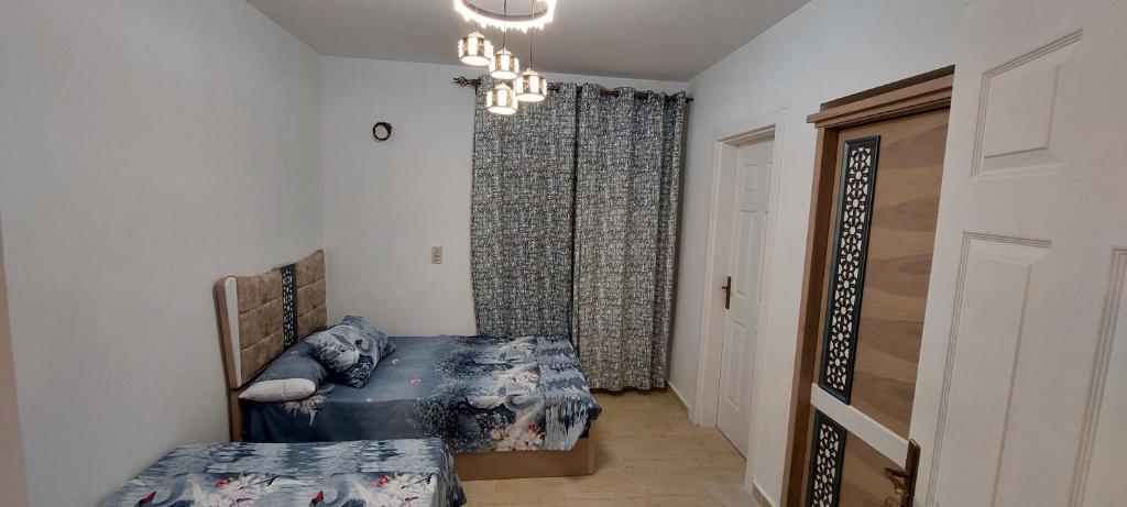 艾因苏赫纳Chalet in Blumar El Dome for families only的一间卧室配有两张床和吊灯。