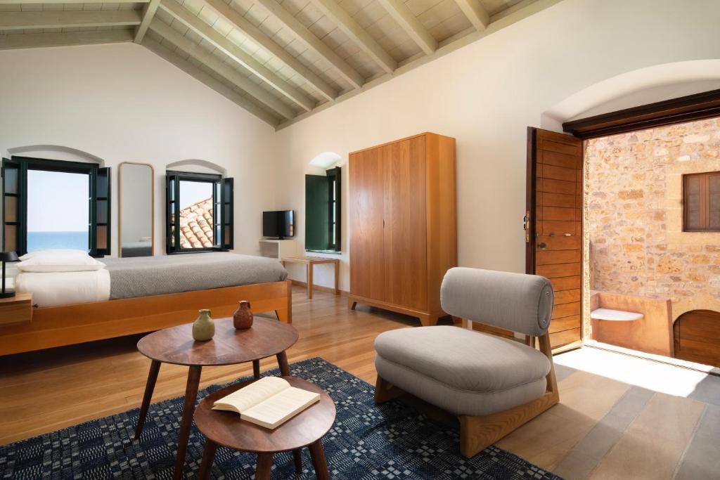 莫奈姆瓦夏Kalnterimi Guesthouses的卧室配有1张床、1张桌子和1把椅子