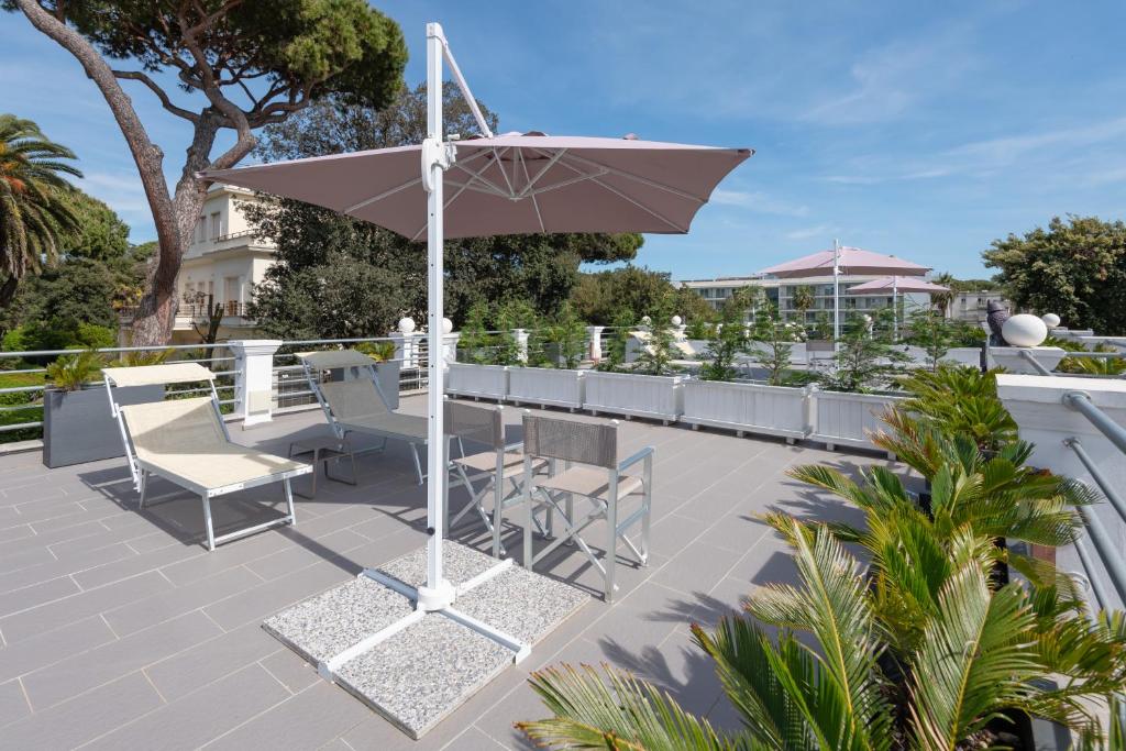 利多迪卡马约雷Lido Luxury Villas的庭院配有桌椅和遮阳伞。