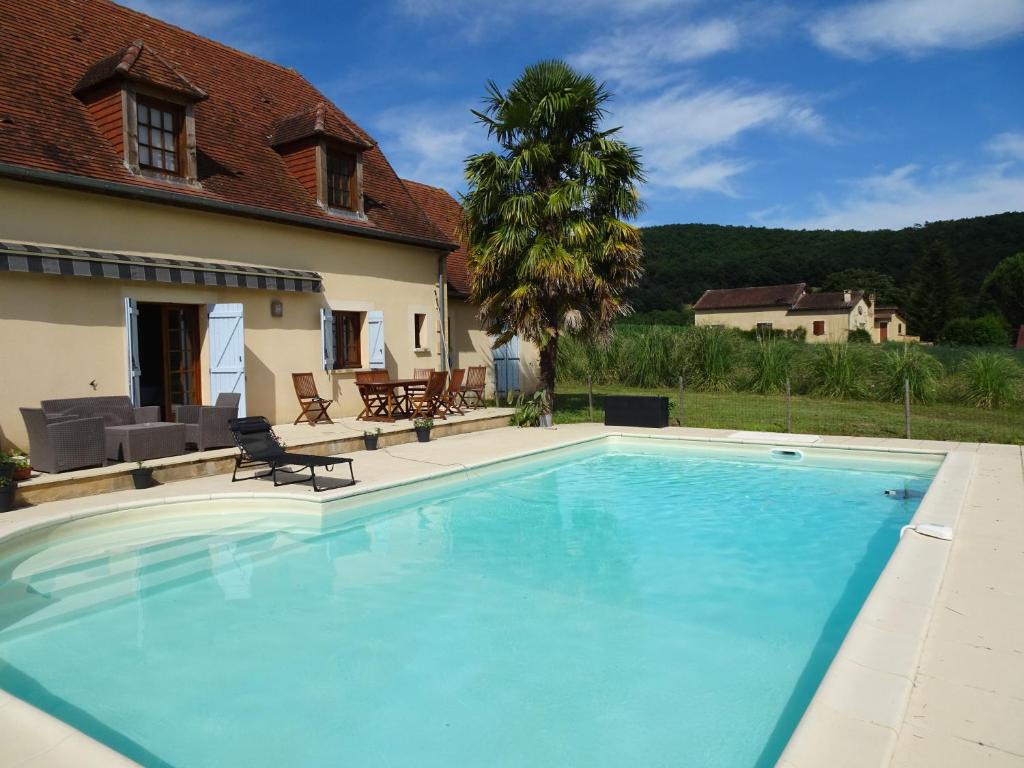 韦扎克Charmante Maison à Vézac au cœur des 5 Châteaux en Dordogne的房屋前的大型游泳池