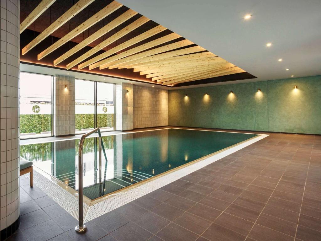 剑桥Novotel Cambridge North的一座带天花板的房屋内的游泳池
