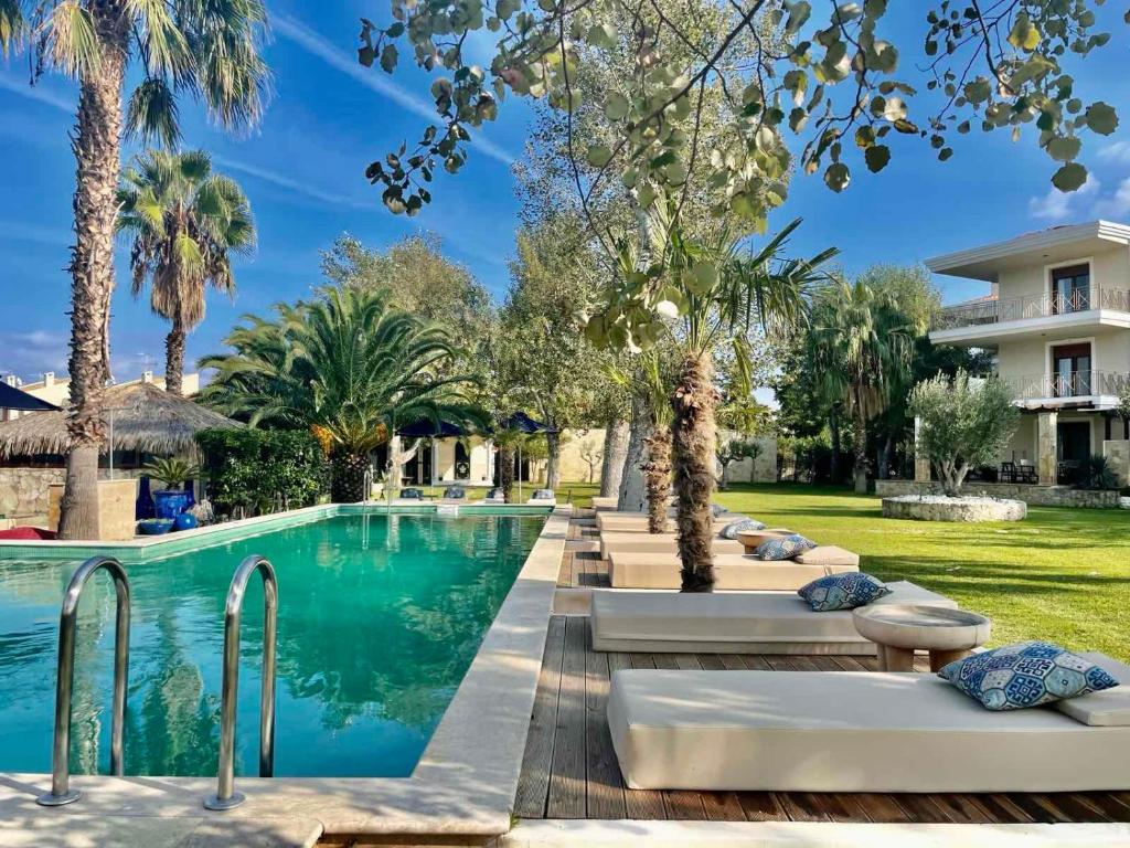 佩科霍里W Villas Halkidiki的一座带躺椅和棕榈树的度假村的游泳池