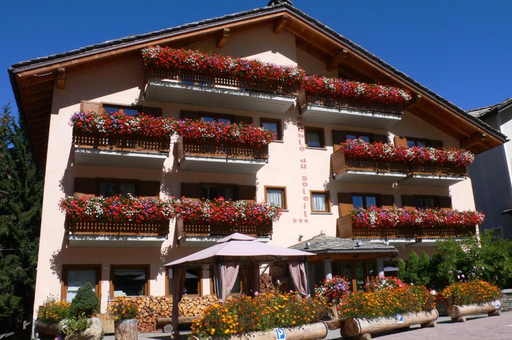 科涅索雷尔酒店的一座带鲜花的阳台和遮阳伞的建筑