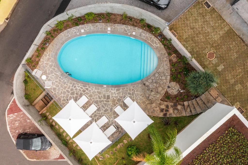 丰沙尔CASA DO MIRADOURO 5 by Heart of Funchal的享有带白色遮阳伞的游泳池的顶部景致