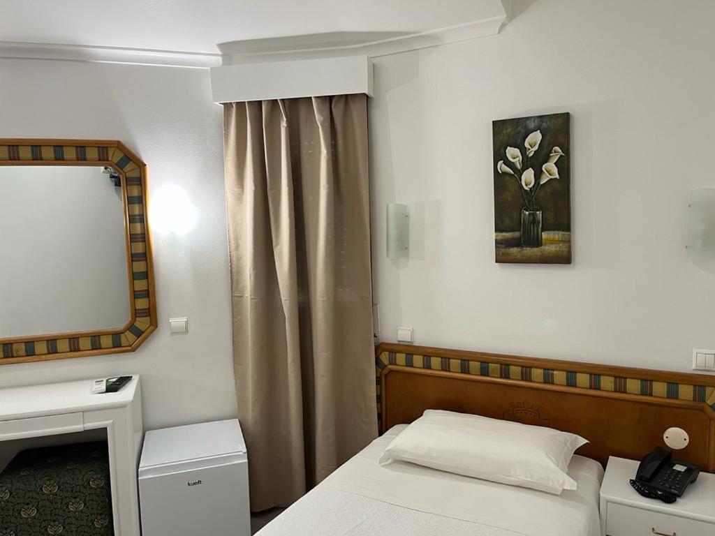 卡帕里卡海岸雷尔卡帕里卡酒店的一间小卧室,配有一张床和镜子