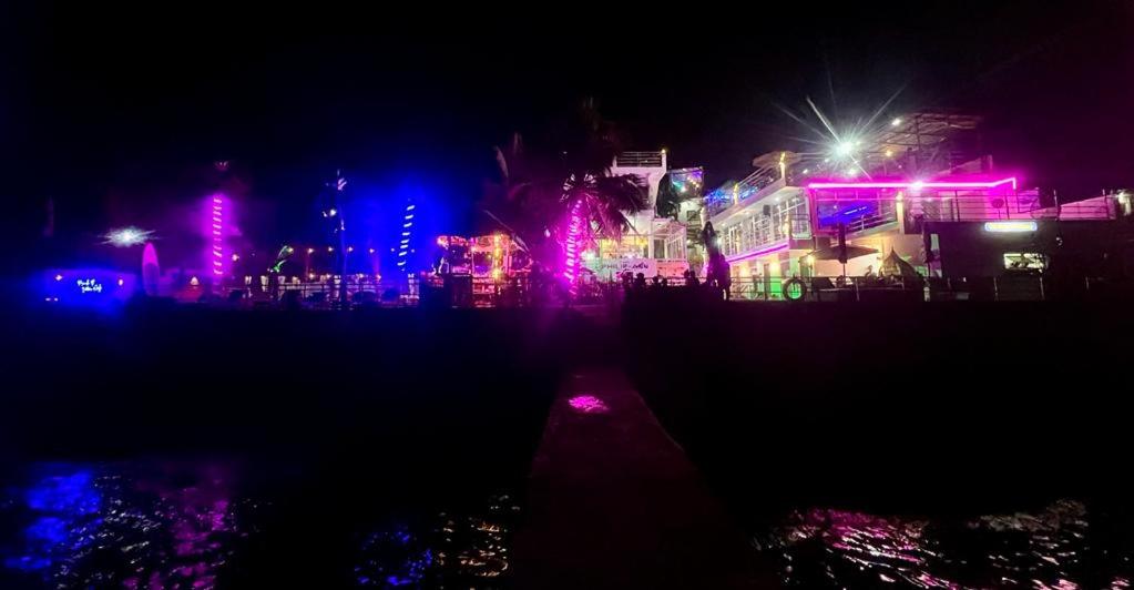 马比尼The Philip Ann Resort的夜晚点燃的城市,粉红色和紫色的灯光
