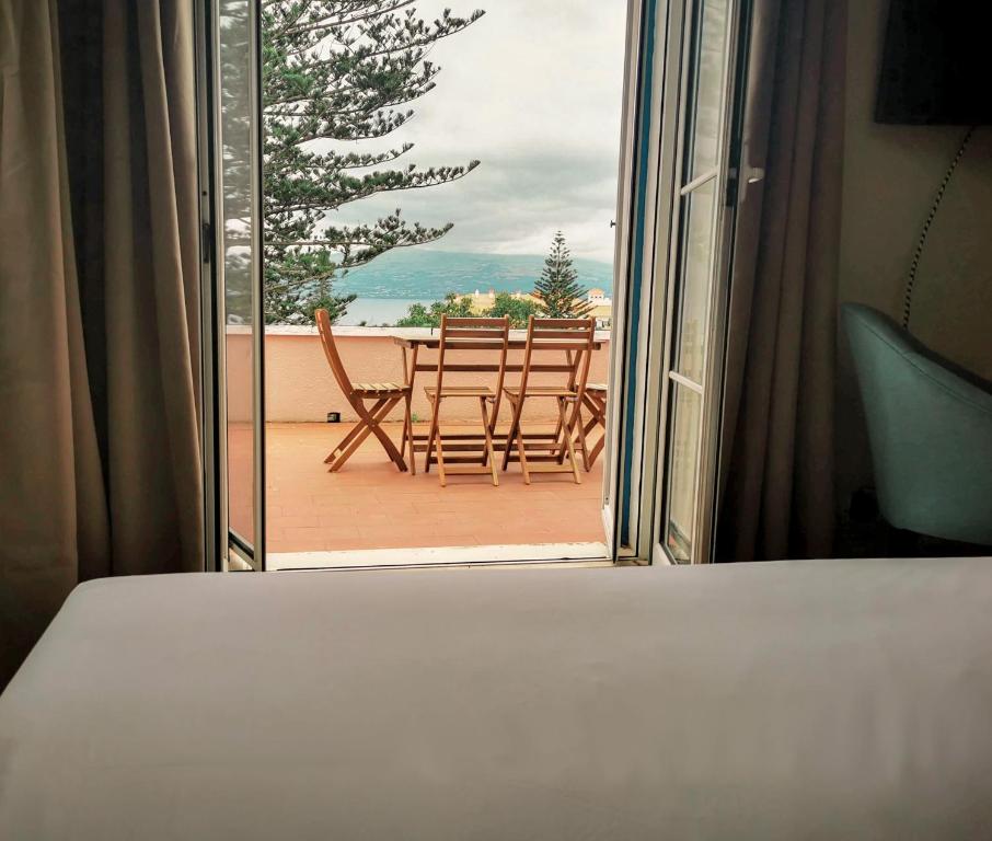 ConceiçãoGarden's Nest - North Villa的一间卧室,享有带桌椅的阳台的景色