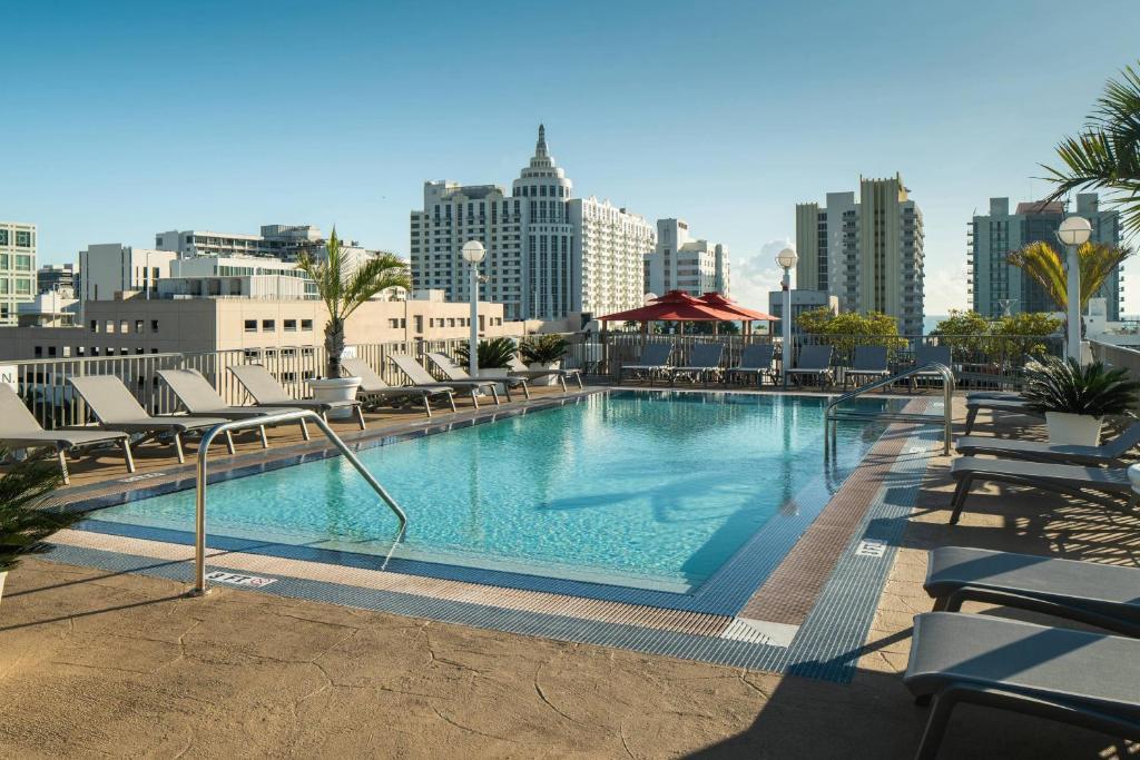 迈阿密海滩迈阿密南海滩万怡酒店的一个带椅子的大型游泳池,享有城市天际线