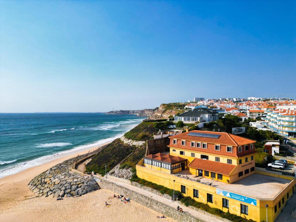 阿雷亚布兰卡HI Areia Branca - Pousada de Juventude的享有海滩、建筑和大海的景色