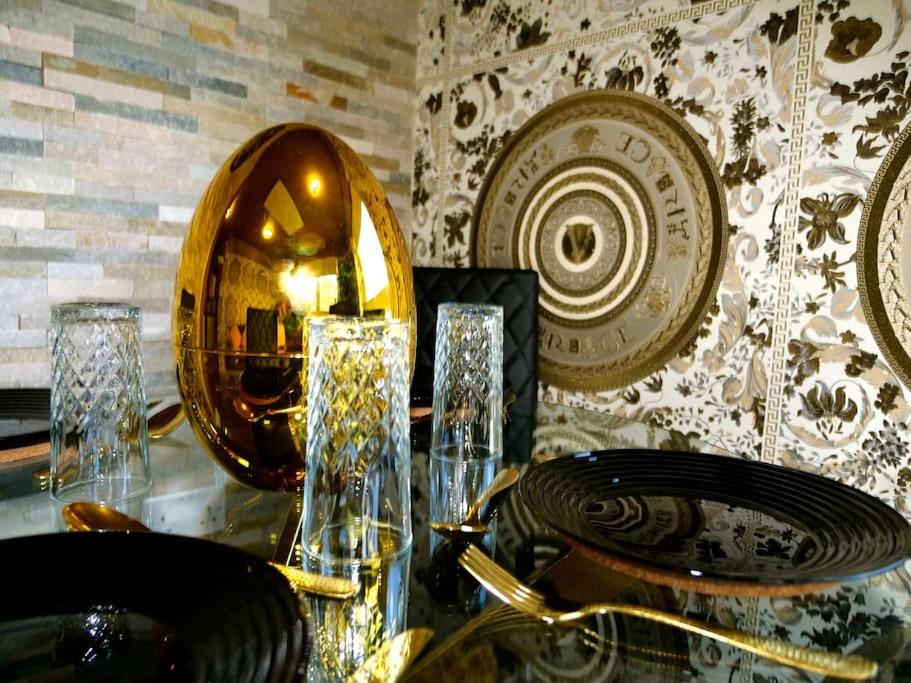 罗瑟勒姆Stunningly Opulent Gold Apartment Near Sheffield FULL SKY TV的一张桌子,上面有盘子和玻璃杯,还有镜子