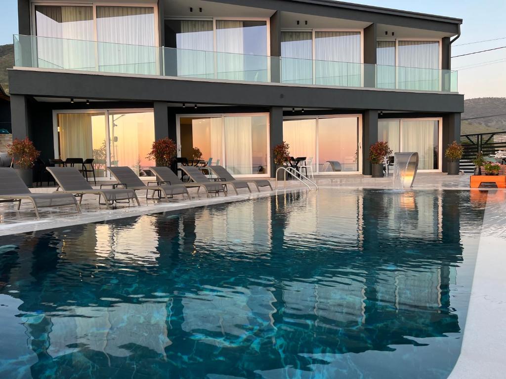 希马拉Casa Del Sol - Luxury Villas的一座建筑前面设有游泳池和椅子